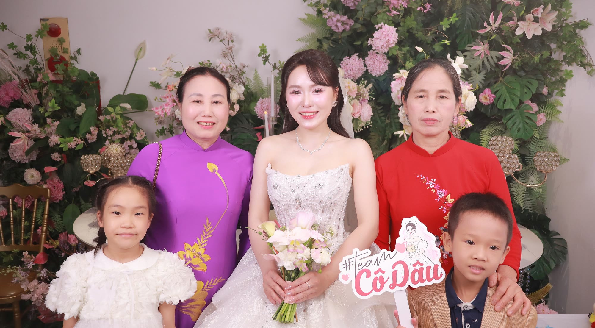 Cô dâu chụp cùng hai mẹ mặc áo dài và các bé tại photobooth Happy Booth